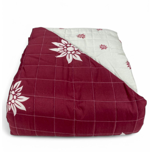 Vista piegata del copriletto Edelweiss rosso con interno chiaro decorato